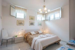 a bedroom with a bed and a chair and windows at Villa Armonia in Praia a Mare