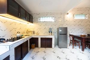 a kitchen with a refrigerator and a table in it at Jungle Forest Villa Ubud by The Travel Ubud Bali in Ubud