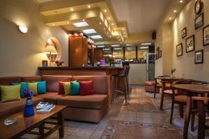 a lobby with a couch and tables and a bar at Hotel Dionysis Studios in Adamas