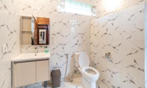 a white bathroom with a toilet and a sink at Jungle Forest Villa Ubud by The Travel Ubud Bali in Ubud