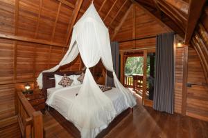 a bedroom with a bed with a mosquito net at Jungle Forest Villa Ubud by The Travel Ubud Bali in Ubud +44 photos