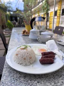 a plate of rice and meat on a table at BC Lodge in Puerto Princesa City