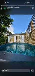 a picture of a swimming pool in front of a house at Bungalow BAO in Fort-de-France