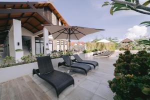 a row of chairs and an umbrella on a patio at Instaworthy 1BR unit at Royal Oceancrest Mactan in Mactan Island