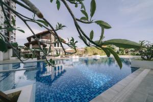 a swimming pool at a resort with trees at Instaworthy 1BR unit at Royal Oceancrest Mactan in Mactan Island