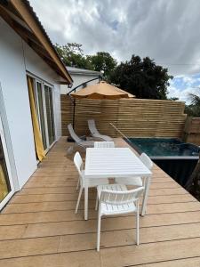 a white table and chairs on a deck with an umbrella at Bungalow BAO in Fort-de-France +7 photos