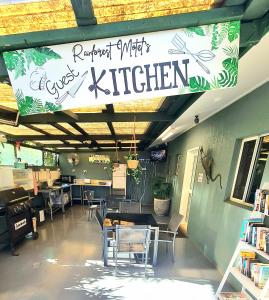 a library with chairs and a sign for a kitchen at Rainforest Motel, Mission Beach in Mission Beach