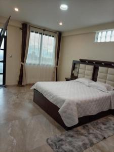 a bedroom with a large bed and a large window at RoofTop in Kollpa