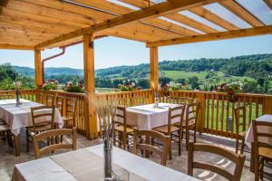 un patio con mesas y sillas en una terraza de madera en Szlovén Mintagazdaság, en Felsőszölnök