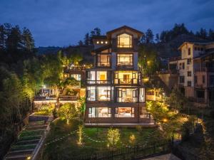 an image of a house at night with lights at Zhangjiajie Cloudscape Villa - New Hotel, Free Private Car Rides to South & East Gates of Zhangjiajie National Forest Park,Free Private Car Rides to & from Airport,Chinese-Western Breakfast, Coffee, Tea & Fruit, Free Laundry & Dryer, Ticket Guidan in Zhangjiajie