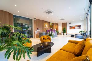 a lobby with a couch and a table and chairs at Quy Nhon Sea Hotel in Quy Nhon