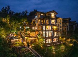 a large house with lights on the side of it at Zhangjiajie Cloudscape Villa - New Hotel, Free Private Car Rides to South & East Gates of Zhangjiajie National Forest Park,Free Private Car Rides to & from Airport,Chinese-Western Breakfast, Coffee, Tea & Fruit, Free Laundry & Dryer, Ticket Guidan in Zhangjiajie