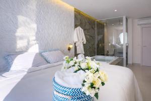 a bedroom with a bed with a tub and flowers on it at D'Blue Búzios Hotel Boutique in Búzios