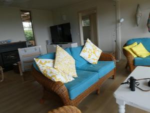 a living room with a blue couch with pillows at Absolute beach front stunning views day and night in Cape Bridgewater