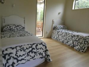a bedroom with two beds with black and white sheets at Absolute beach front stunning views day and night in Cape Bridgewater