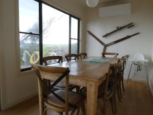 a dining room with a wooden table and chairs at Absolute beach front stunning views day and night in Cape Bridgewater