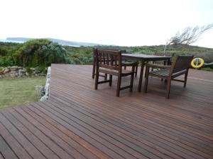 a wooden deck with two benches and a table at Absolute beach front stunning views day and night in Cape Bridgewater