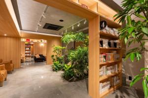 a lobby with plants and bookshelves in a library at Gran Custama Ueno in Tokyo