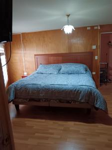 a bedroom with a bed with a blue comforter at Eluney 3 in Valdivia