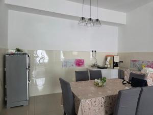 a kitchen with a table with chairs and a refrigerator at D'BROGA HILL Homestay in Kampong Solok