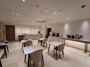 a restaurant with tables and chairs in a room at Hotel Hariu in Gwangju