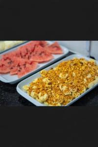 two trays of food on a table with watermelon at Pousada Doce Mar in Maragogi +28 photos
