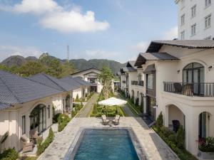 a pool in the middle of a row of houses at Narci Resort Tam Coc in Ninh Binh