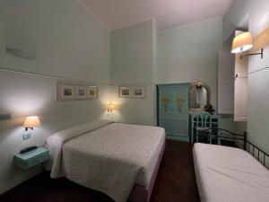 a small room with two beds and a mirror at Lilium Boutique Hotel in Rome