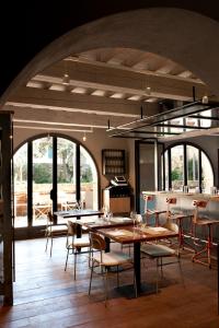 uma sala de jantar com mesas, cadeiras e janelas em La Bandita Townhouse em Pienza