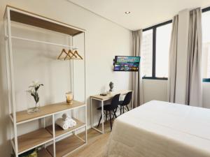 a bedroom with a bed and a desk and a table at Apê Smart Santos - Praia do Gonzaga in Santos