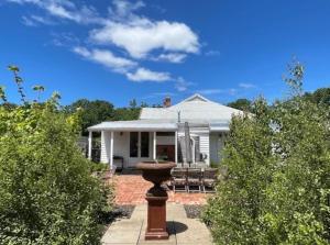 a white house with a bird bath in front of it at Oakview Country House Maffra in Maffra