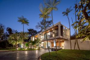 a house with palm trees in front of it at Cicada Estate in Ban Mae Pu Kha