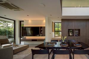 a living room with a dining table and a tv at Cicada Estate in Ban Mae Pu Kha