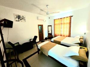 a hotel room with two beds and a couch at Elephant safari Lodge sigiriya junction in Habarana +56 photos