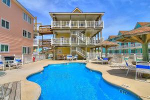 a resort with a swimming pool with chairs and a building at Beachgate Condo Suites and Hotel 218 condo in Port Aransas +1 photo