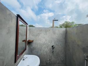 a bathroom with a sink and a mirror and a window at Habarana Tree House - Ivory cottage in Habarana +68 photos