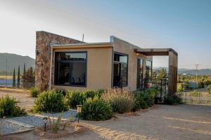 a small house with a lot of windows at Flor de Garambullo, Valle de Guadalupe in Valle de Guadalupe