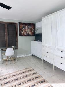 a room with a white dresser and a white chair at Casa Buenavista in Mérida