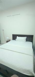 a bedroom with a white bed with a wooden headboard at Hangang M building in Avati