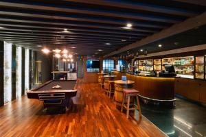 a bar with a pool table and bar stools at The First Collection Marina, Dubai, a Tribute Portfolio Hotel in Dubai