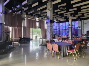 a dining room with tables and chairs and windows at Arafah Hotel Nilai in Kampong Tanjong +38 photos