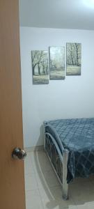 a bedroom with a bed with four pictures on the wall at Agradable habitación C in Mexicali