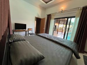 a bedroom with a large bed and a television at Jin Pool Villa in Ban Khok Chakohan +56 photos