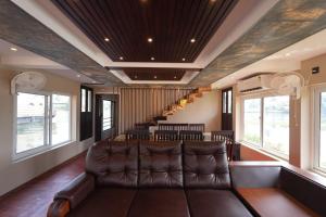 a living room with a leather couch and a staircase at My Trip Houseboats in Alleppey
