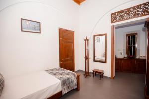 a bedroom with a bed and a mirror at Cinnamon Legacy in Weligama +10 photos