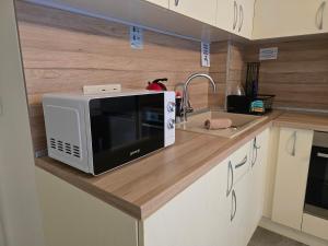 a microwave sitting on a counter in a kitchen at Xelibri Apartment in Gorna Oryakhovitsa