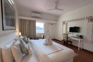 a living room with a white bed and a desk at Sanskriti Vedic Retreat in Rishīkesh