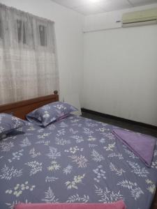 a bedroom with a bed with a blue comforter and pillows at Sahan tours in Padukka