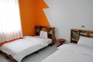 two beds in a room with orange walls at Mocha Vila Mộc Châu in Mộc Châu
