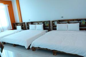 three beds in a room with white sheets at Mocha Vila Mộc Châu in Mộc Châu